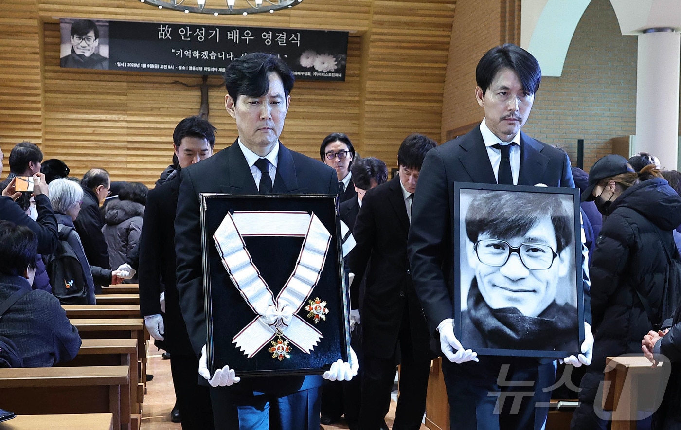 배우 이정재와 정우성이 9일 오전 서울 중구 명동성당에서 열린 고 안성기의 영결식장에서 고인의 영정과 훈장을 든 채 이동하고 있다. (공동취재) 2026.1.9/뉴스1 ⓒ News1 권현진 기자