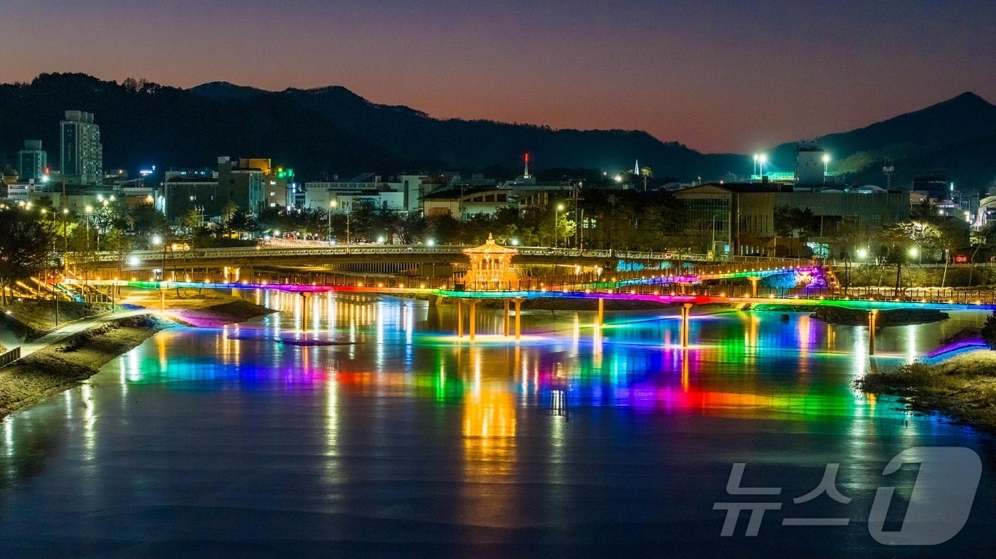 충북 괴산군 괴산읍 성황천과 동진천을 연결하는 에코브릿지의 경관조명이 얼음에 반영돼 겨울밤 수변의 이색적인 풍경을 연출하고 있다.(괴산군 제공).2026.1.9/뉴스1 