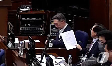 윤석열 전 대통령이 9일 오후 서울 서초구 서울중앙지방법원에서 열린 내란 우두머리 혐의 1심 결심 공판에 출석해 시계를 보고 있다. (서울중앙지방법원 제공 영상 캡쳐. 재판매 및 DB 금지) 2026.1.9/뉴스1