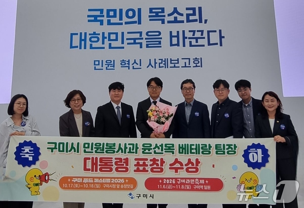 구미시의 '베테랑 원스톱 민원팀' 윤선목 팀장이 지난 2일 민원혁신 사례보고회에서 대통령상을 받은뒤 정성현 부시장, 팀원들과 기념사진을 찍고 있다.
