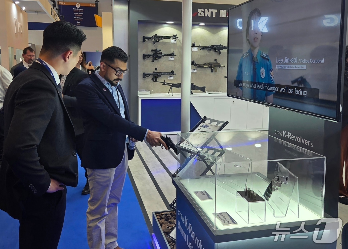 WDS 2026 내 SNT모티브 전시관을 찾은 한 관계자가 저위험권총을 살펴보고 있는 모습 (SNT모티브 제공. 재판매 및 DB금지)