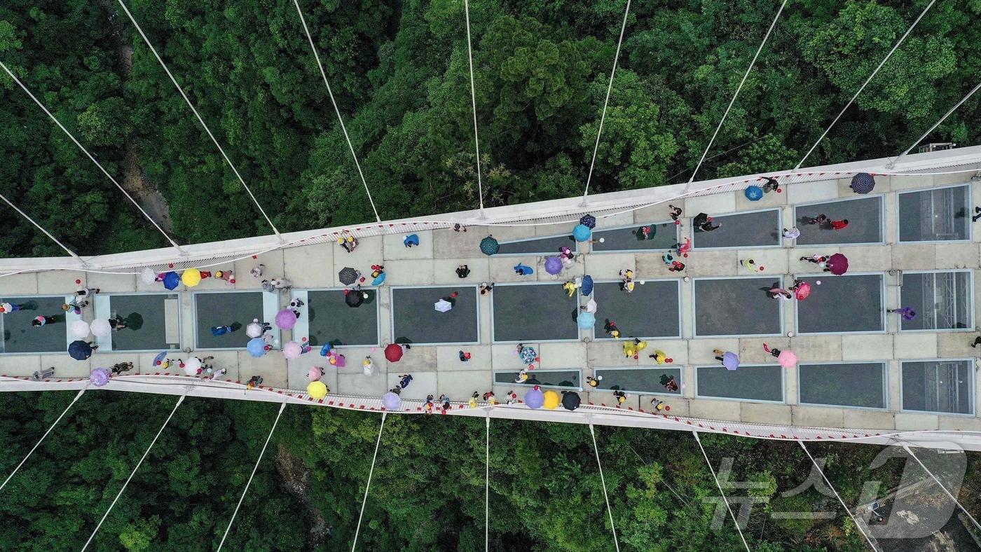 관광객들이 장자제(장가계) 대협곡 유리다리를 걷고 있다. 2021.6.20 ⓒ AFP=뉴스1