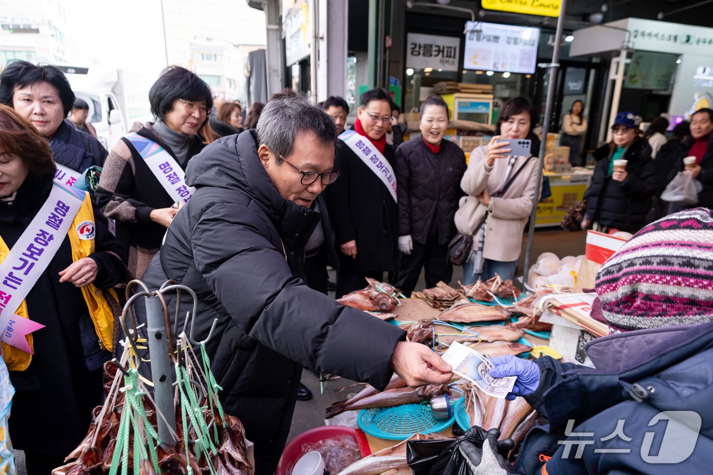 김홍규 강원 강릉시장이 11일 강릉 중앙·성남시장에서 열린 전통시장 장보기 행사에서 지역 화폐를 내고 물건을 구입하고 있다.(강릉시 제공, 재판매 및 DB 금지) 2026.2.11/뉴스1