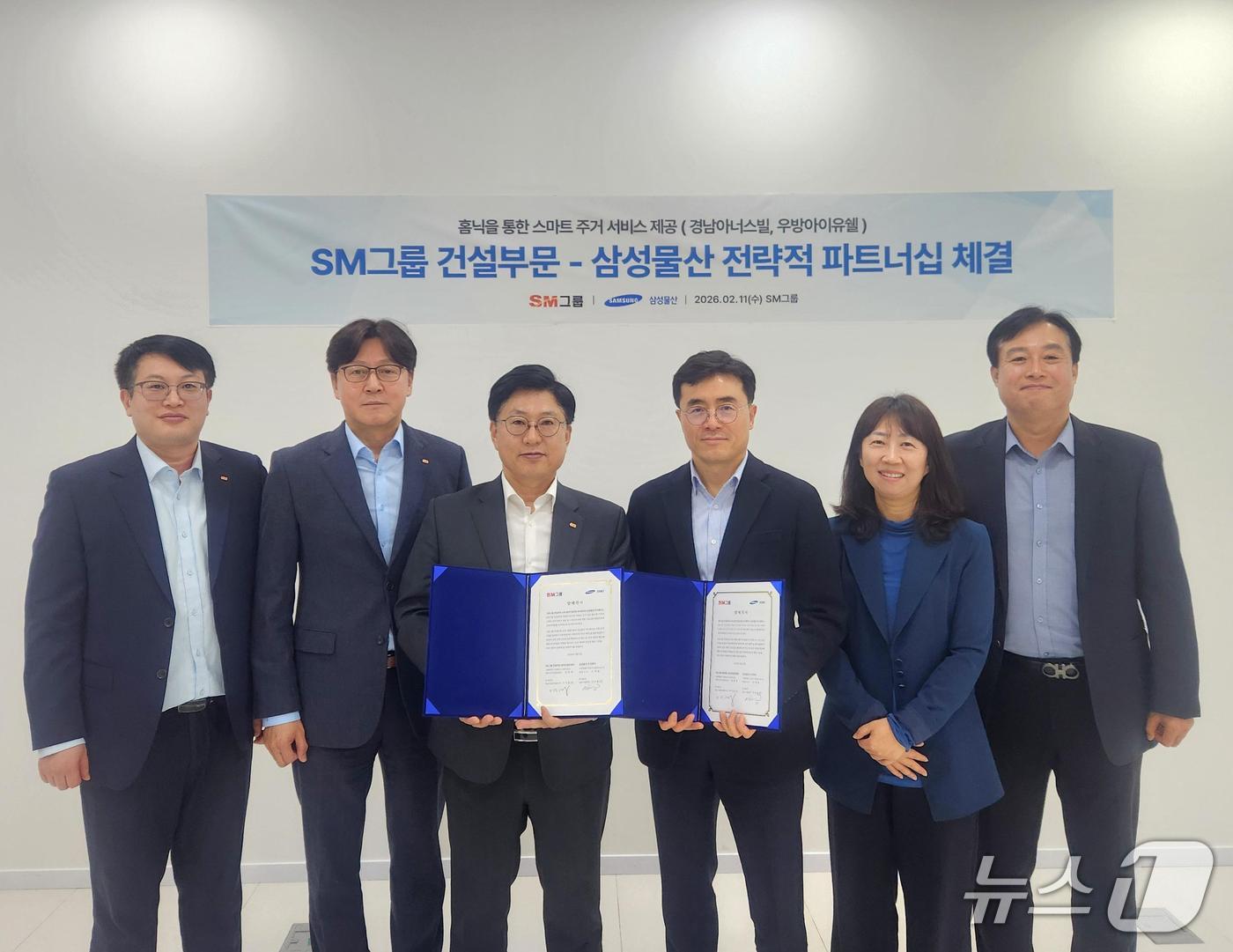 임동복 SM그룹 건설부문장 (왼쪽 세 번째)과 이주용 삼성물산 건설부문 DxP사업부장(오른쪽 세 번째)이 지난 11일 서울 서대문구 SM그룹 신촌사옥에서 홈플랫폼 '홈닉'(Homeniq)을 통한 스마트 주거 서비스 기술교류 협력을 위한 양해각서를 체결한 뒤 양 사 주요 참석자들과 기념촬영을 하고 있다. (SM그룹 제공) 뉴스1 ⓒ News1