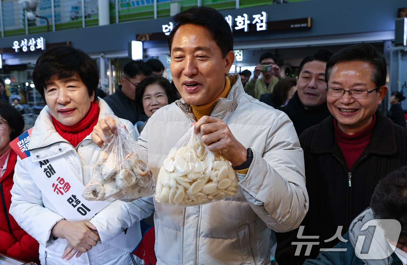 오세훈 서울시장이 설 연휴 첫날인 14일 서울 영등포전통시장을 찾아 떡을 구입하고 있다. 2026.2.14 ⓒ 뉴스1 김도우 기자