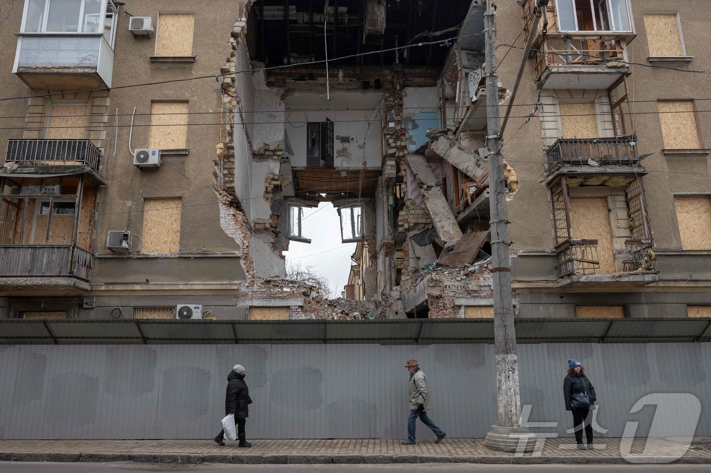 17일(현지시간) 우크라이나 오데사에서 러시아군의 공습으로 크게 파손된 건물 앞을 시민들이 지나고 있다. 2026.02.16. ⓒ AFP=뉴스1