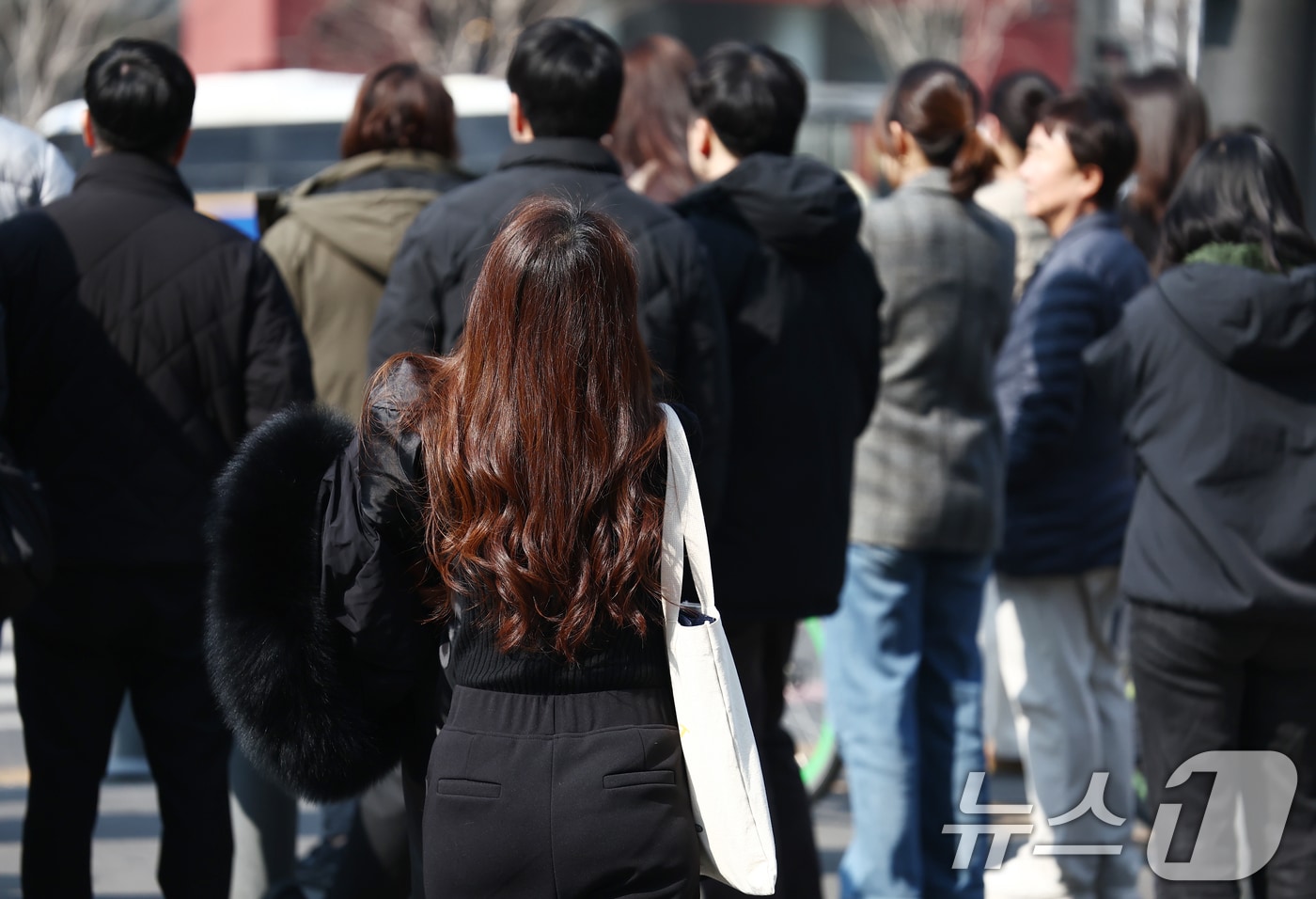 서울 낮 최고 기온이 10도 이상 오르며 포근한 날씨를 보인 20일 오후 서울 광화문 사거리에서 시민이 외투를 들고 발걸음을 옮기고 있다. 2026.2.20 ⓒ 뉴스1 김민지 기자