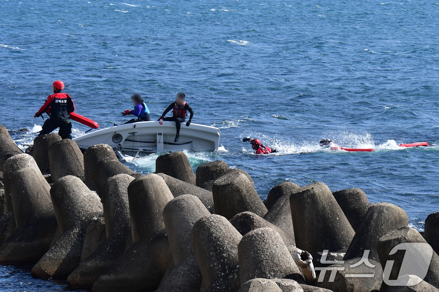 22일 낮 12시20분쯤 경북 포항시 북구 환여동 앞 바다에서 포항해양경찰서 구조대와 포항북부소방서 119구조대가 좌초된 딩기요트 탑승자들을 구조하고 있다. 2026.2.22 ⓒ 뉴스1 최창호 기자