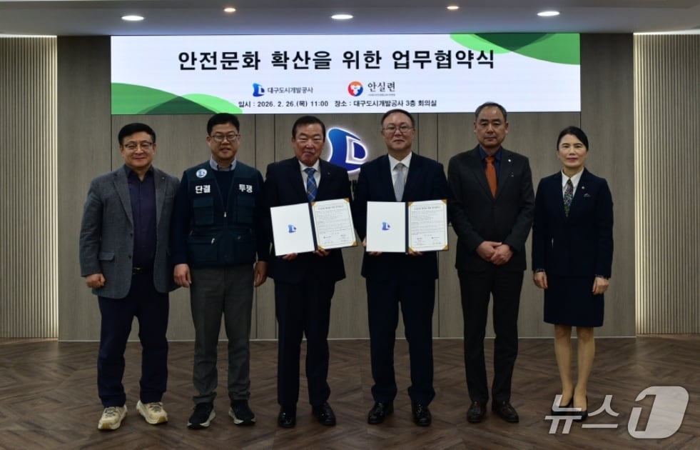 정명섭 대구도시개발공사 사장(왼쪽 세번째)과 박주현 대구안전생활실천시민연합 공동대표(오른쪽 세번째)가 안전문화 확산을 위한 업무협약을 체결한 뒤 협약서를 펼쳐 보이고 있다.(대구도시개발공사 제공, 재판매 및 DB 금지)