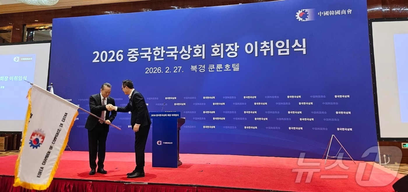 27일 베이징 쿤룬호텔에서 개최된 중국 한국상회 회장 이취임식에서 양걸 삼성전략협력실 사장이자 전임 회장이 이혁준 현대차 중국법인 총재 겸 신임 회장에 회기를 전달하고 있다. ⓒ 뉴스1 정은지 특파원