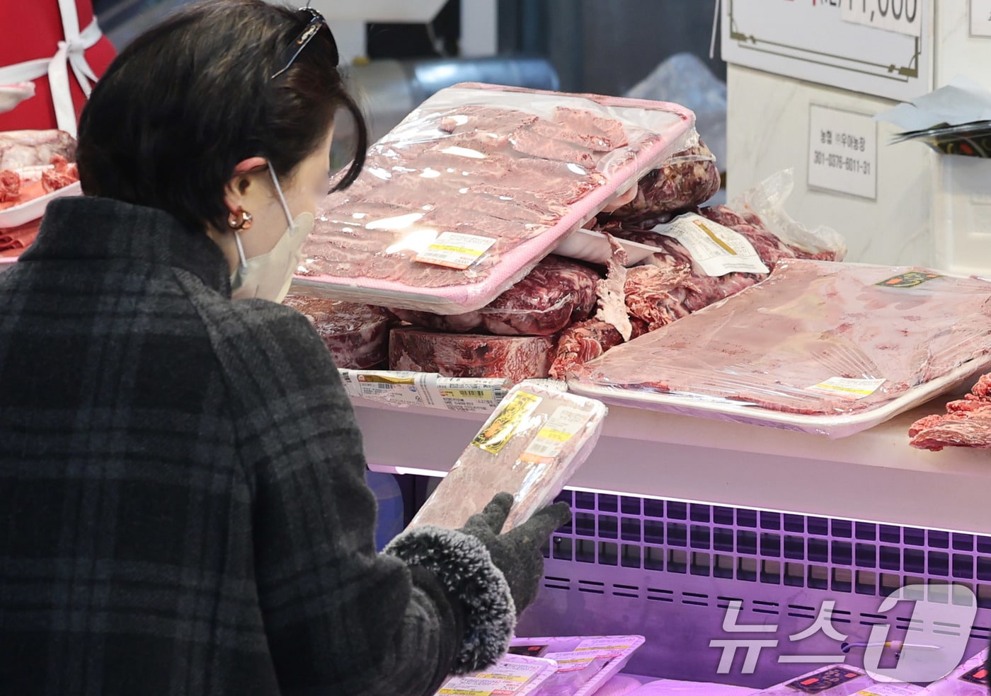 설 연휴를 앞둔 8일 서울 동대문구 청량리종합시장에서 한 시민이 한우를 살펴보고 있다. 올해 설 성수품 가운데 배추·무·과일 등 농산물 가격은 대체로 안정세지만, 한우·계란·조기 등 축산·수산물은 지난해보다 높은 수준을 보이고 있다. 구제역·아프리카돼지열병(ASF)·고병원성 AI 확산 영향으로 축산물 가격 강세가 이어지며, 한우 등심과 돼지고기 삼겹살 가격도 1년 전보다 각각 상승했다. 2026.2.8 ⓒ 뉴스1 박지혜 기자