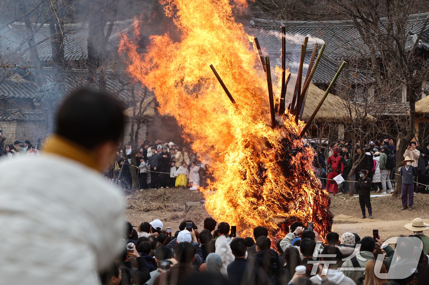 정월대보름을 이틀 앞둔 1일 경기 용인시 기흥구 한국민속촌에서 열린 달집태우기 행사에서 시민들이 타오르는 달집을 바라보며 소원을 빌고 있다. 2026.3.1 ⓒ 뉴스1 김도우 기자