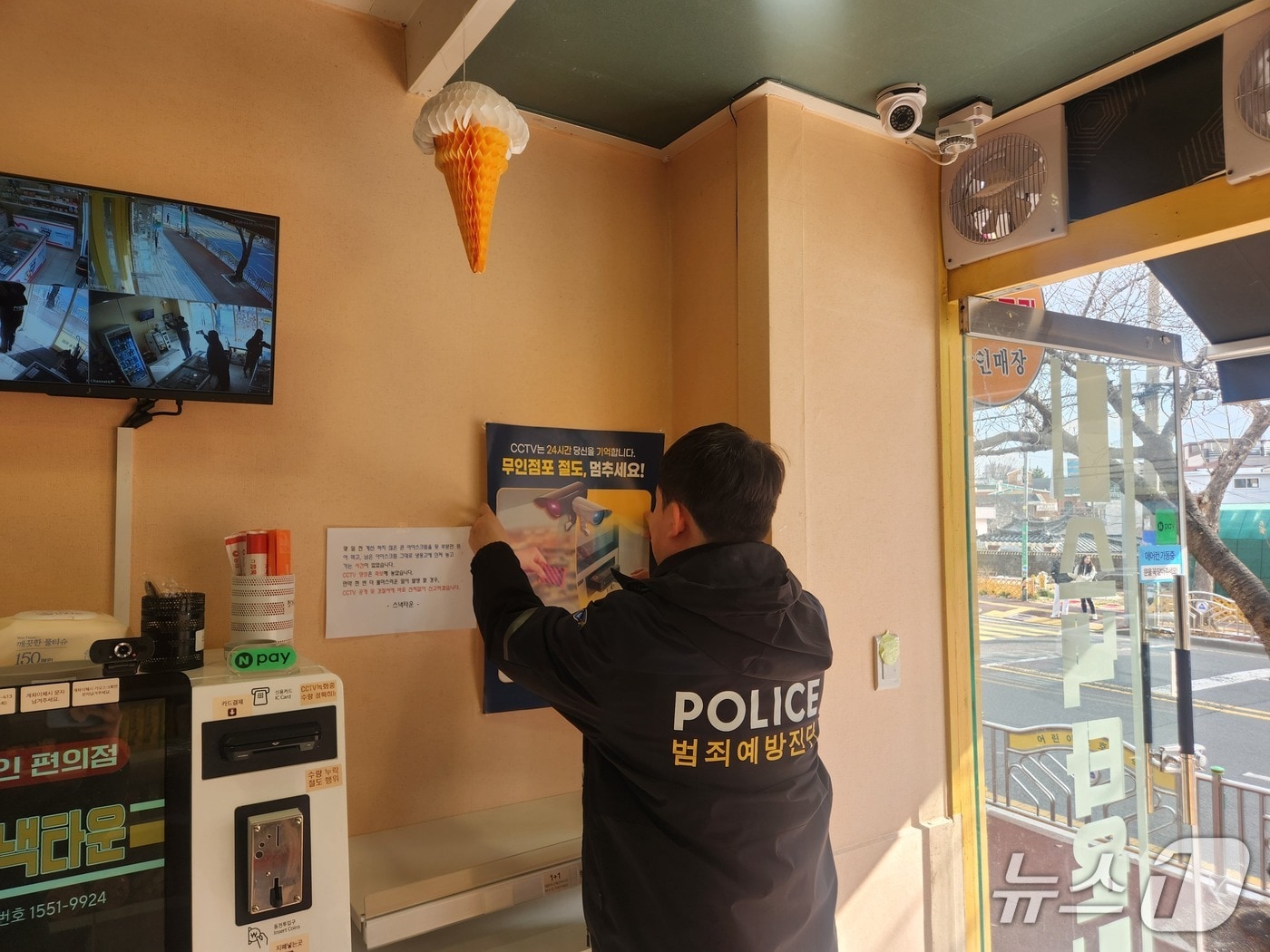 울산경찰이 10일 무인 매장에 범죄 예방 홍보 포스터를 붙이고 있다.(울산경찰청 제공. 재판매 및 DB금지)/뉴스1