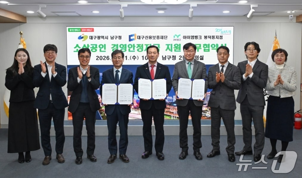 박진우 대구신용보증재단 이사장(왼쪽 네번째)과 조재구 남구청장(가운데)이 소상공인 경영안정자금 지원을 위한 업무협약을 체결한 뒤 협약서를 펼쳐 보이고 있다.(대구신보 제공. 재판매 및 DB 금지)