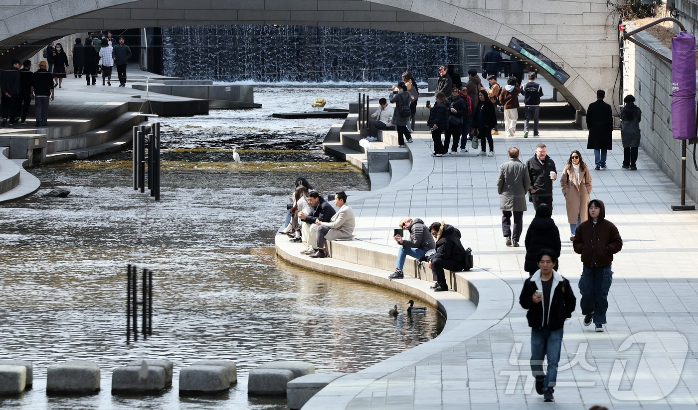 서울의 낮 최고기온이 14도를 기록하는 등 포근한 날씨를 보인 12일 오후 서울 종로구 청계천을 찾은 시민들이 휴식을 취하고 있다. 2026.3.12 ⓒ 뉴스1 김진환 기자