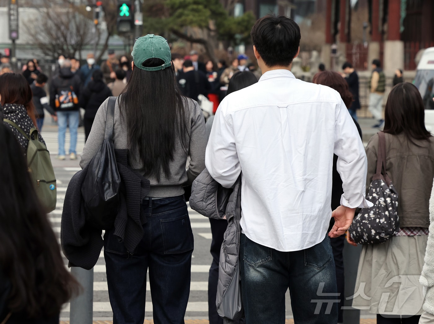 서울의 낮 최고기온이 14도를 기록하는 등 포근한 날씨를 보인 12일 오후 서울 종로구 광화문사거리에서 시민들이 외투를 손에 들며 거리를 지나고 있다. 2026.3.12 ⓒ 뉴스1 김진환 기자