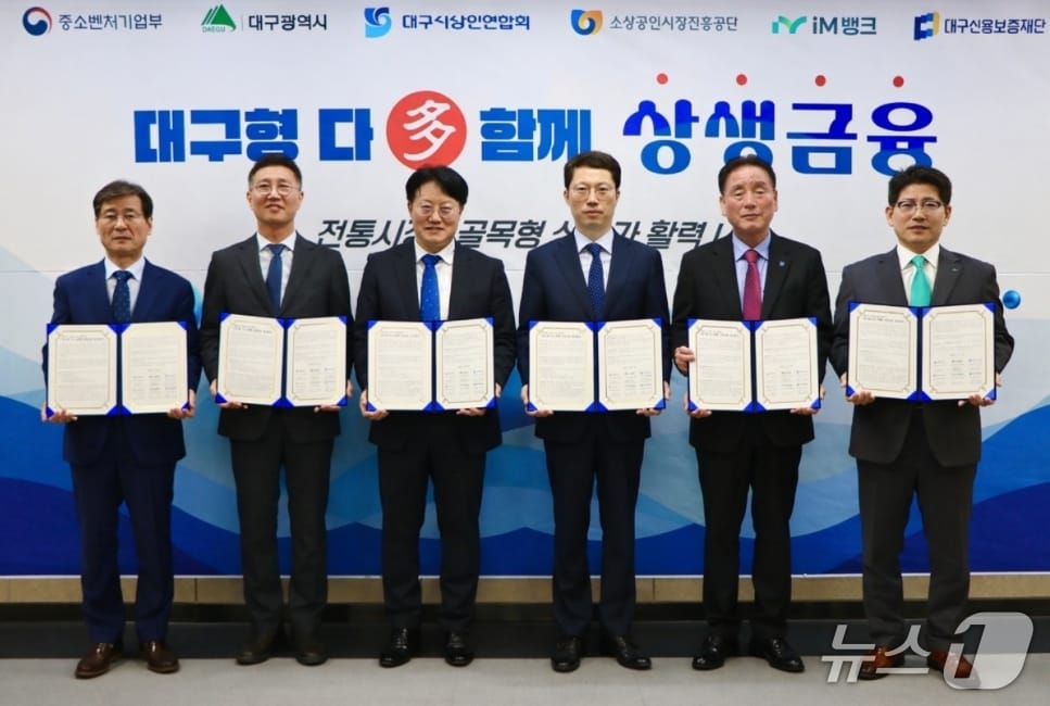 박진우 대구신용보증재단 이사장(왼쪽부터), 김현석 소상공인시장진흥공단 대구경북지역본부장, 정기환 대구경북지방중소벤처기업청장, 박기환 대구시 경제국장, 박재청 대구시상인연합회 회장, 류희장 iM뱅크 여신그룹장이 '대구형 다(多) 함께 상생금융 업무협약'을 체결한 후 협약서를 펼쳐 보이고 있다.(대구신보 제공, 재판매 및 DB 금지)