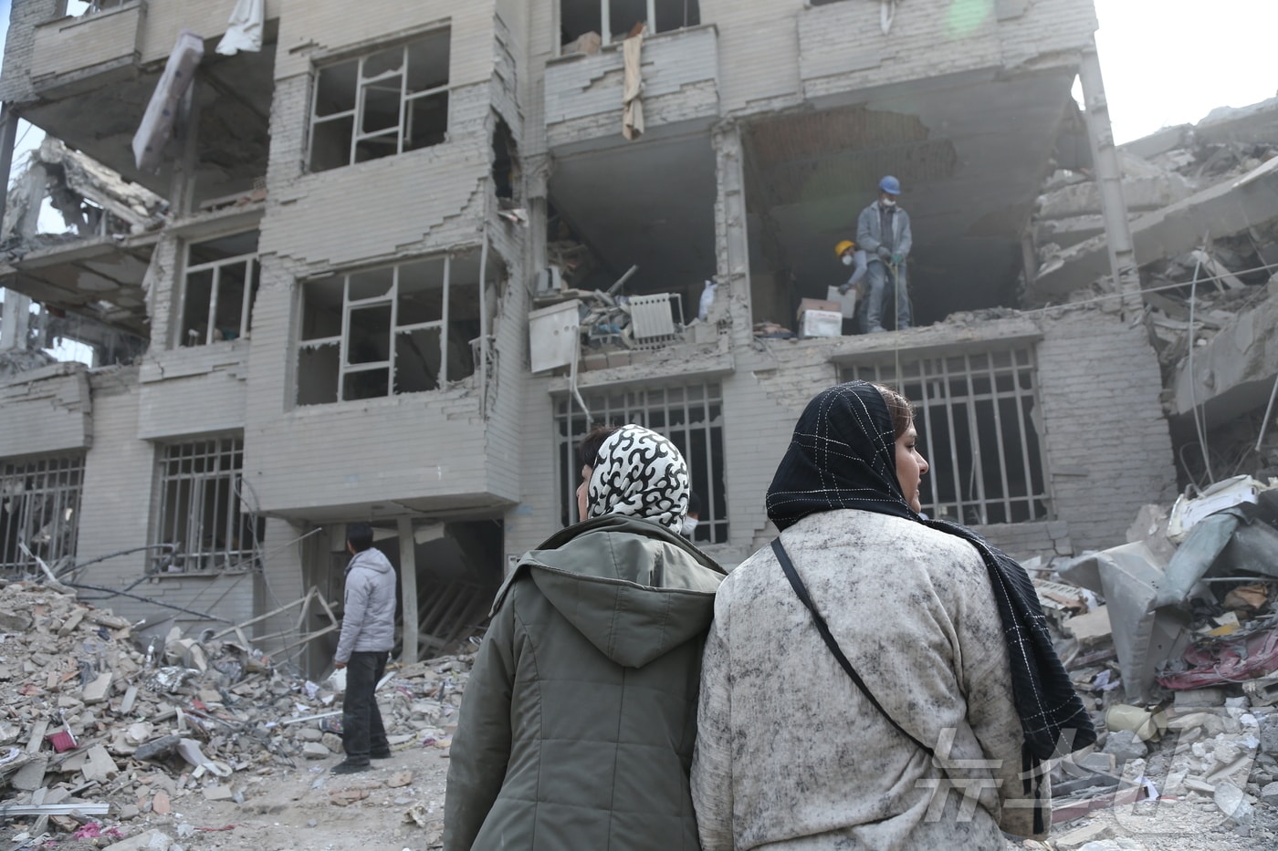 12일(현지시간) 이란 수도 테헤란의 폐허 속에서 주민들이 폭격에 손상된 건물을 뒤져 생필품을 찾고 있다. 2026.3.12 ⓒ 신화=뉴스1