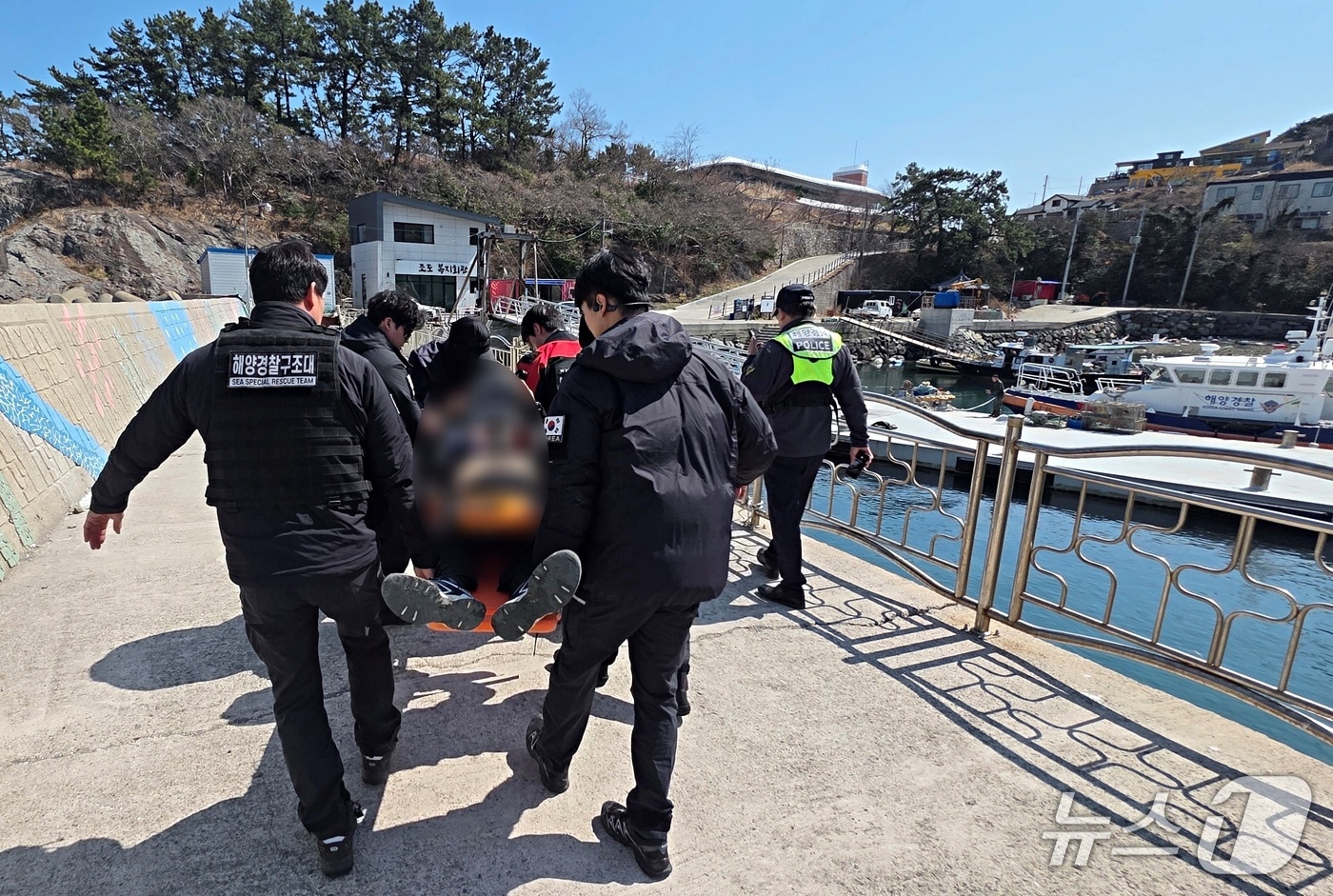 14일 테트라포드에서 추락해 의식이 없는 낚시객을 해경이 이송하고 있다.(사천해경 제공. 재판매 및 DB 금지)