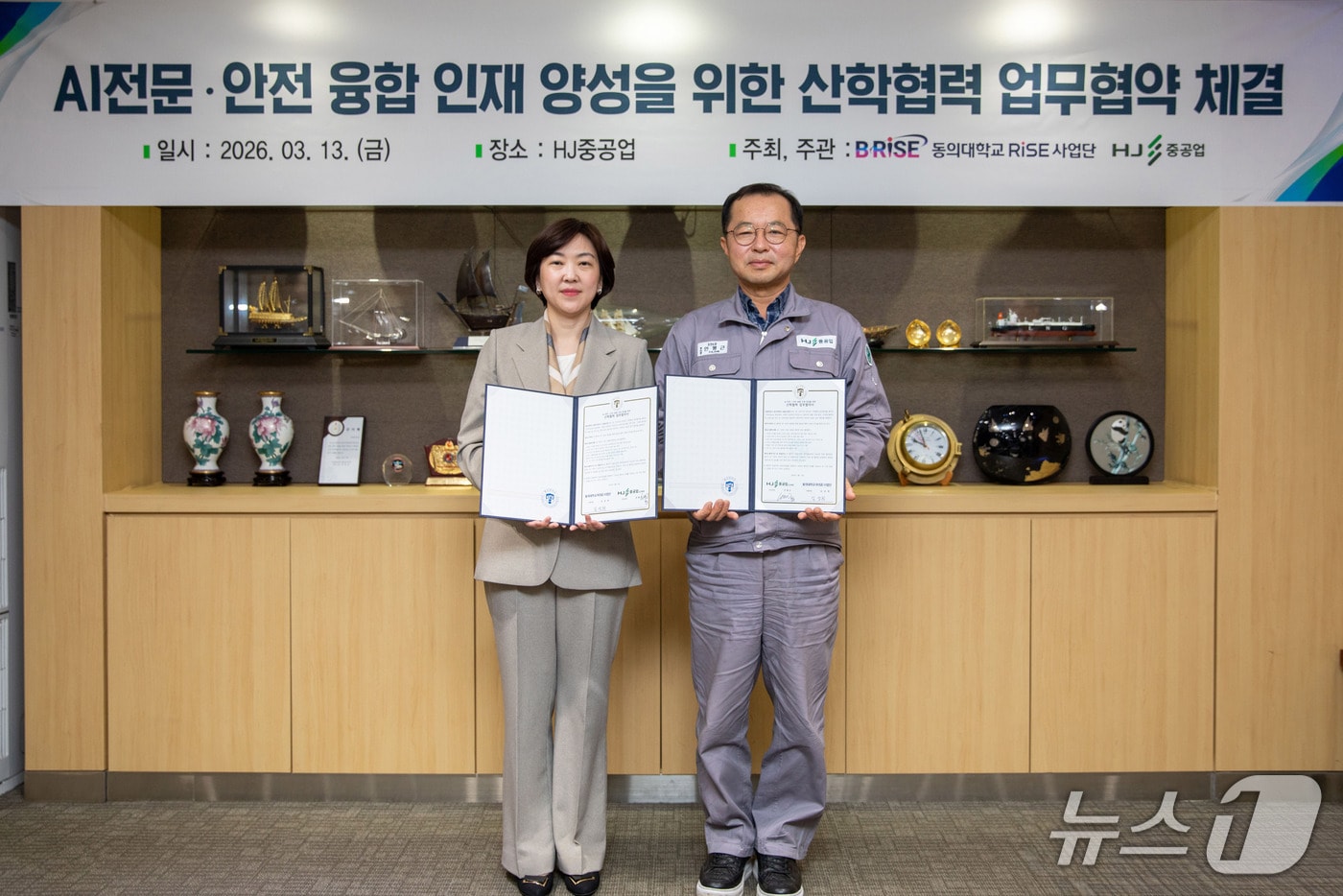 HJ중공업에서 열린 AI전문·안전 융합 인재 양성을 위한 산학협력 업무 협약식에서 김성희 동의대 RISE사업단장(왼쪽)과 안평근 HJ중공업 조선소장이 협약서를 들어보이고 있다. (동의대 제공. 재판매 및 DB 금지)