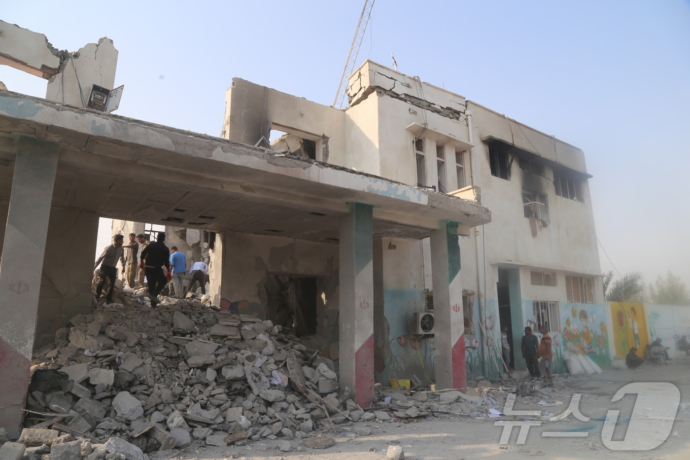 지난 2월28일(현지 시간) 이란 남부 호르모즈간주 미나브에 위치한 여자초등학교 폭격 현장에서 구조대와 주민들이 부상자를 구조하고 있다. ⓒ 신화=뉴스1