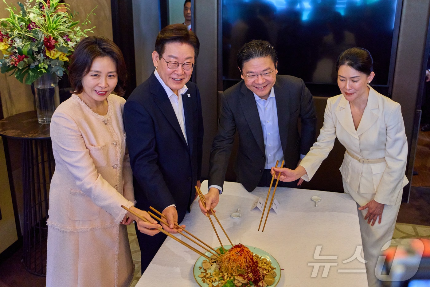 이재명 대통령과 김혜경 여사, 로렌스 웡 싱가포르 총리, 루 즈 루이 여사가 2일(현지시간) 싱가포르 한 호텔에서 열린 친교 오찬에서 생선회 샐러드 ‘유생’을 함께 섞고 있다. (공동취재) 2026.3.2 ⓒ 뉴스1 허경 기자