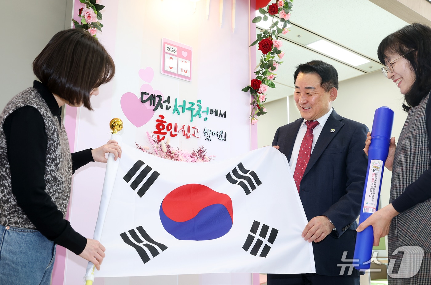 서철모 서구청장이 구청 민원실을 방문한 국제결혼 부부에게 태극기를 전하고 있다.(서구 제공. 재판매 및 DB금지)/뉴스1