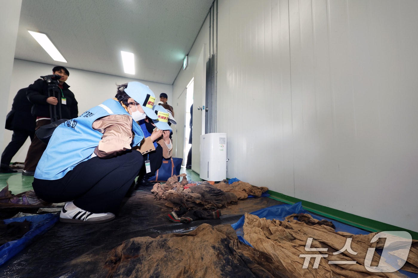 20일 오후 전남 무안군 무안국제공항에서 여객기 참사 유가족들이 179명의 희생자들의 유류품이 보관된 장소에 주저 앉아 눈물 흘리고 있다. 2026.3.20 ⓒ 뉴스1 박지현 기자