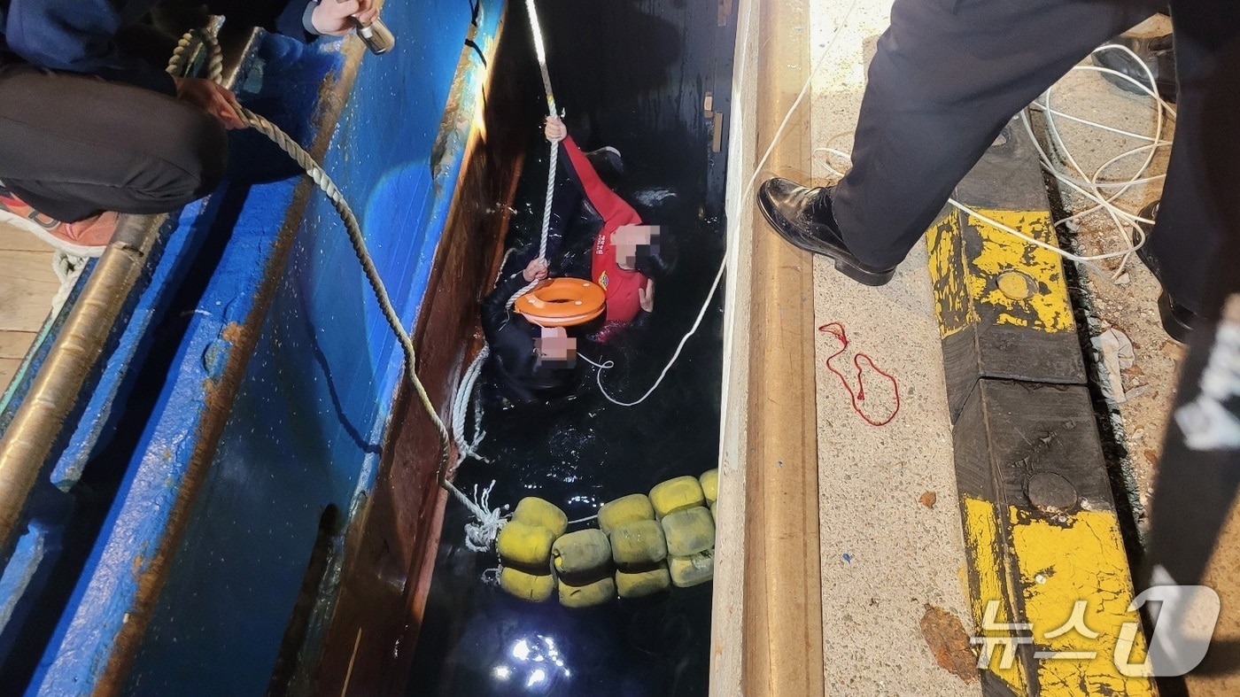 지난 20일 밤 감천항 국제수산물유통센터 앞 해상에서 선박에 승선하던 중 바다로 추락한 A 씨를 해경이 구조하고 있다.(부산해경 제공. 재판매 및 DB금지)