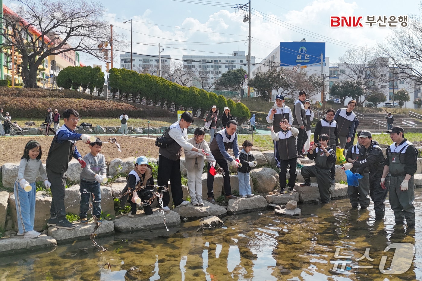 지난 21일 김성주 부산은행장 및 직원들이 부산 동래구 온천천일대에서 EM흙공 및 미꾸라지 방류 등 생태계 개선 활동을 하는 모습 (부산은행 제공. 재판매 및 DB금지)