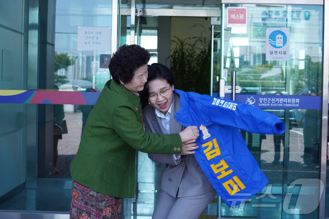 22일 제9회 전국동시지방선거 더불어민주당 강진군수 예비후보로 등록한 김보미 전남 강진군의원(36·여)에게 한 지지자가 민주당 점퍼를 입혀주고 있다.(김보미 제공, 재배포 및 DB 금지)2026.3.23 ⓒ 뉴스1