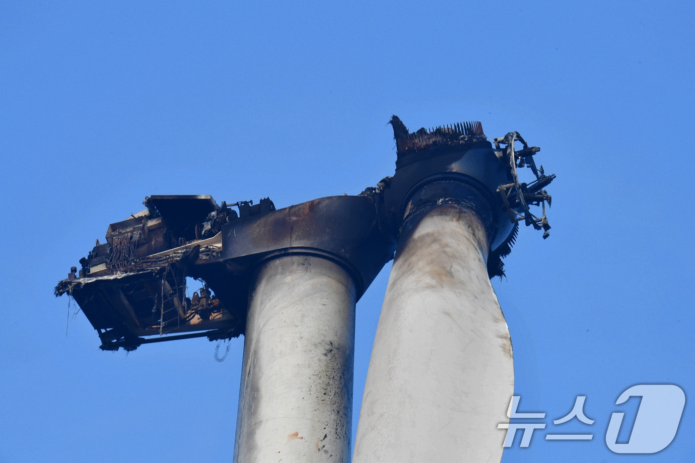 경북 영덕군 창포리 풍력발전기 화재 이틀째인 24일 오전 소방당국이 발전기 블레이드에 남은 불을 진화하고 있다. 불로 새까맣게 탄 발전기 모습.2026.3.24 ⓒ 뉴스1 최창호 기자