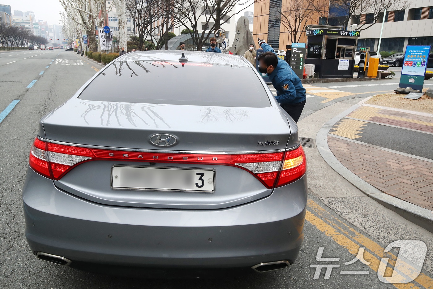 공공부문 승용차 5부제(요일제) 의무 시행 첫날인 25일 오전 대구 수성구청 입구에서 구청 청원경찰이 부제 대상 차량(수요일·차량 끝자리 3, 8번) 운전자에게 인근 주차장 이용을 안내하고 있다. 2026.3.25 ⓒ 뉴스1 공정식 기자