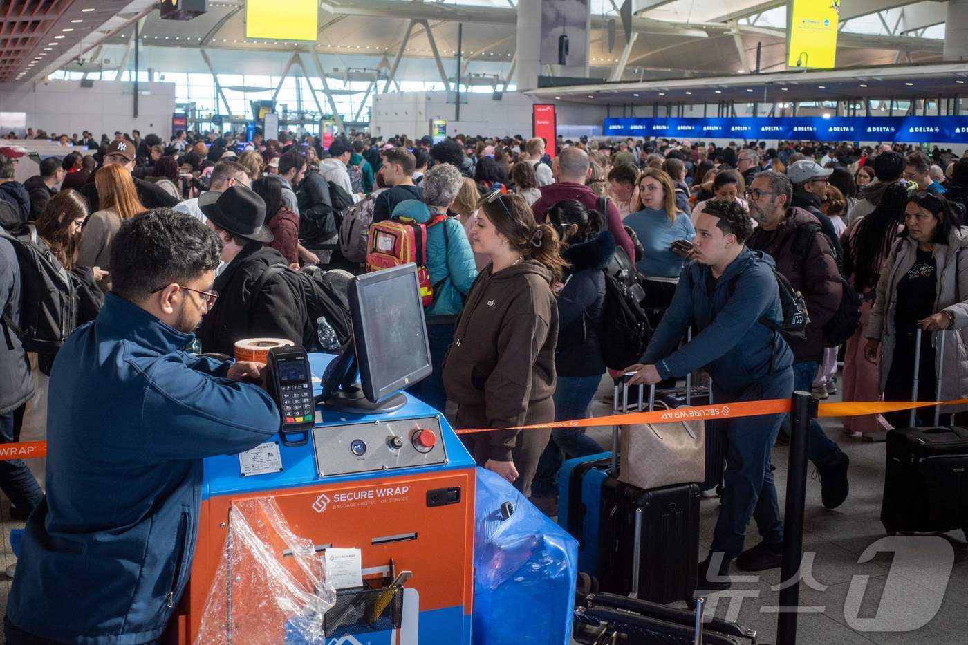 25일(현지시간) 뉴욕 JFK국제공항을 이용하려는 탑승객들이 보안검색을 받기 위해 길게 줄을 서 있다. 미국 국토안보부(DHS) 부분 셧다운(일시적 업무 중단)이 6주째 이어지며 무급 근무에 버티지 못한 교통안전청(TSA) 직원이 500명 가까이 사직하고 3100명 이상이 결근해 '공항 대란'이 심화되고 있다. 이로 인해 교통안전청(TSA) 역사상 가장 긴 대기 시간이 발생했으며, 일부 공항에선 4시간 반이 넘게 대기하고 있다. 도널드 트럼프 대통령은 공항 업무 지원을 위해 주방위군 투입을 검토하고 있다. ⓒ AFP=뉴스1