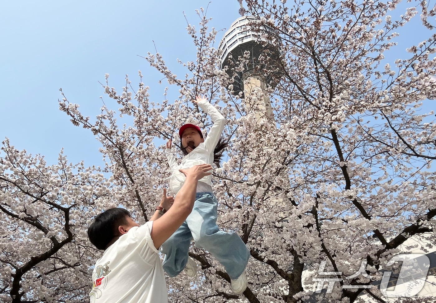 27일 대구 달서구 테마파크 이월드를 찾은 시민들이 활짝 핀 벚꽃을 배경으로 사진을 찍고 있다. 2026.3.27 ⓒ 뉴스1 공정식 기자