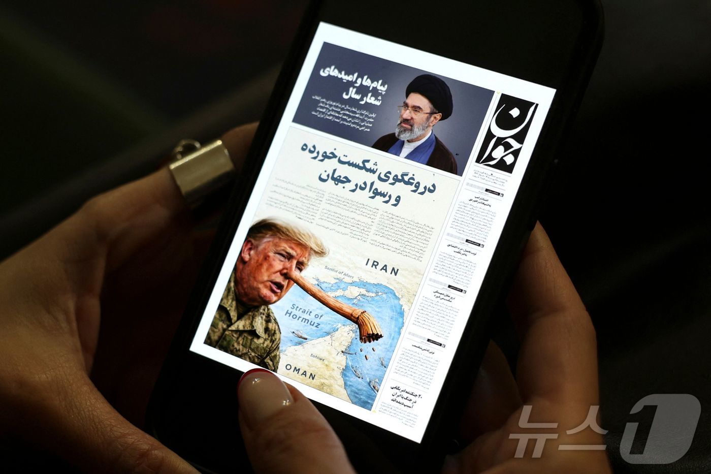 한 이란 여성이 25일(현지시간) 테헤란에서 자바 신문의 디지털 사본을 휴대전화로 읽고 있다. 2026.3.25 ⓒ AFP=뉴스1