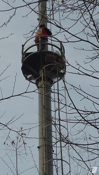 택시노동자 고영기 씨가 맹성규 더불어민주당 의원 사무실 앞 통신탑에 올라가고 있다. (민주노총 공공운수노조 택시지부 제공)