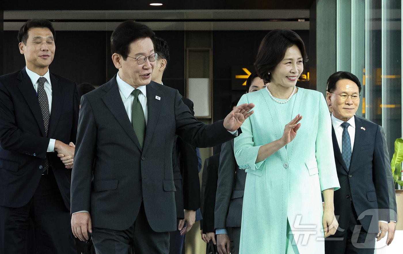 이재명 대통령과 김혜경 여사가 3일(현지시간) 필리핀 국빈 방문을 위해 싱가포르 창이 국제공항에서 공군 1호기로 이동하며 공항 직원들에게 인사하고 있다. ⓒ 뉴스1 허경 기자
