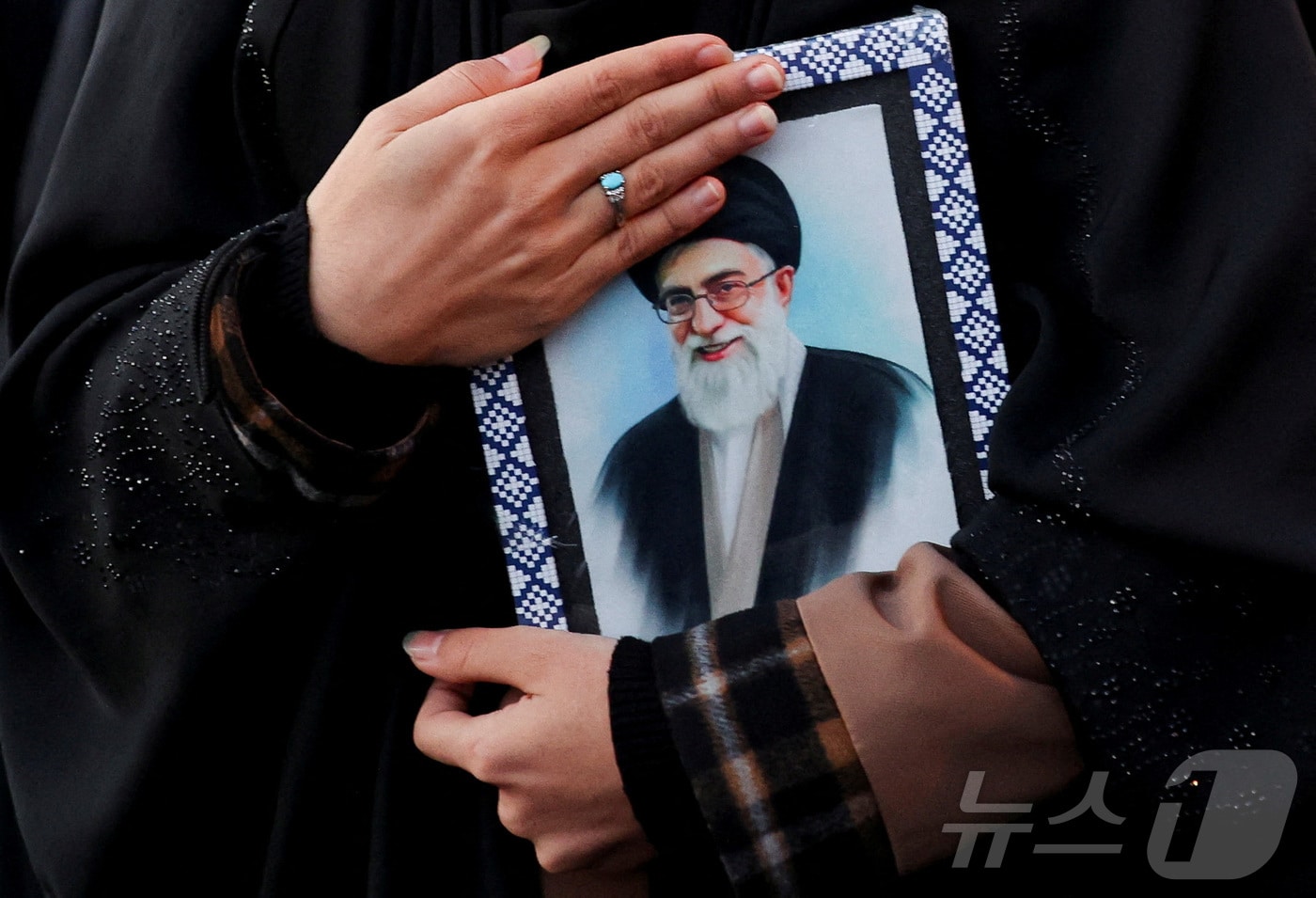 사망한 하메네이 사진을 품에 안은 이란 테헤란의 하나 주민. 2026.03.01 ⓒ 로이터=뉴스1