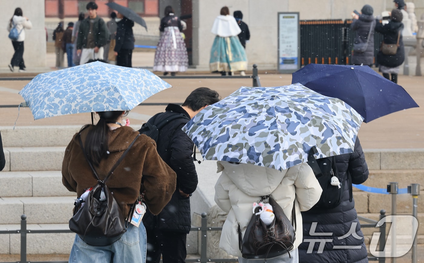 6일 서울 종로구 경복궁 앞에서 관광객들이 우산을 쓰고 지나고 있다. 이날 기상청 적설 관측에 따르면 서울은 오전 9시 기준 서대문에서 0.1㎝의 적설이 관측됐다. 다만 서울 도심에서는 오전 9시 20분 전후 약 10분가량 강한 눈이 내린 뒤 그쳤다. 2026.3.6 ⓒ 뉴스1 임세영 기자