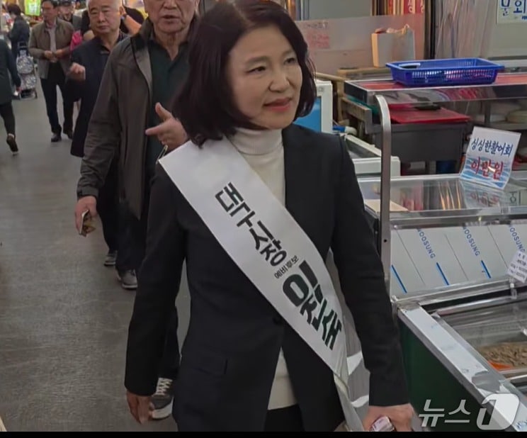 이진숙 전 방송통신위원장이 지난 12일 '대구시장 예비후보 이진숙' 이라는 어깨띠를 하고 전통시장을 누비며 지지를 호소하는 모습. (SNS 갈무리) ⓒ 뉴스1
