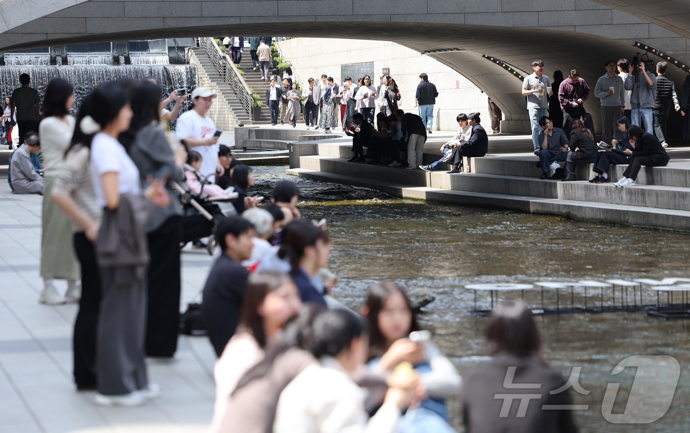 서울 낮 최고 기온이 28도까지 오르는 등 초여름 날씨를 보인 14일 서울 중구 청계천을 찾은 시민들이 여유로운 시간을 보내고 있다. 2026.4.14 ⓒ 뉴스1 김성진 기자