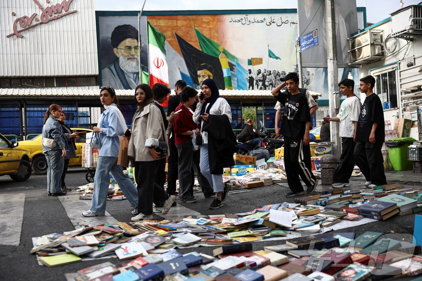 13일(현지시간) 이란 테헤란에서 시민들이 이란의 전 최고 지도자 아야톨라 알리 하메네이의 벽화 옆을 지나가고 있다. 2026.04.13 ⓒ 로이터=뉴스1
