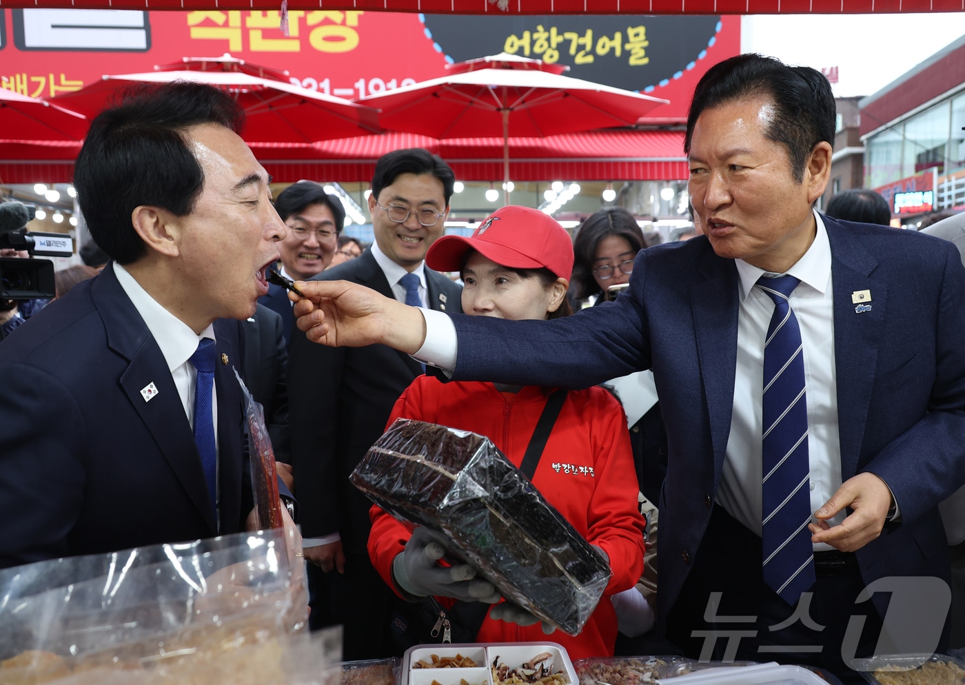 정청래 더불어민주당 대표가 20일 충남 보령 대천항수산시장에서 박수현 충남도지사 후보에게 김을 먹여주고 있다. 2026.4.20 ⓒ 뉴스1 김기태 기자