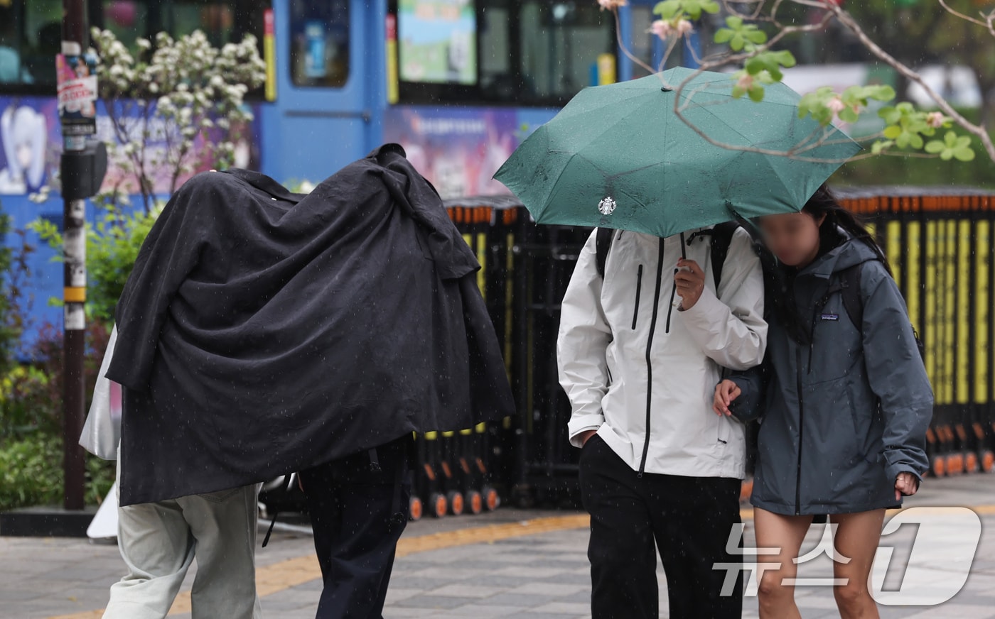 서울 중구 시청역 인근에서 겉옷을 두른 시민들이 비를 피하고 있다. 2026.4.20 ⓒ 뉴스1 임지훈 인턴기자
