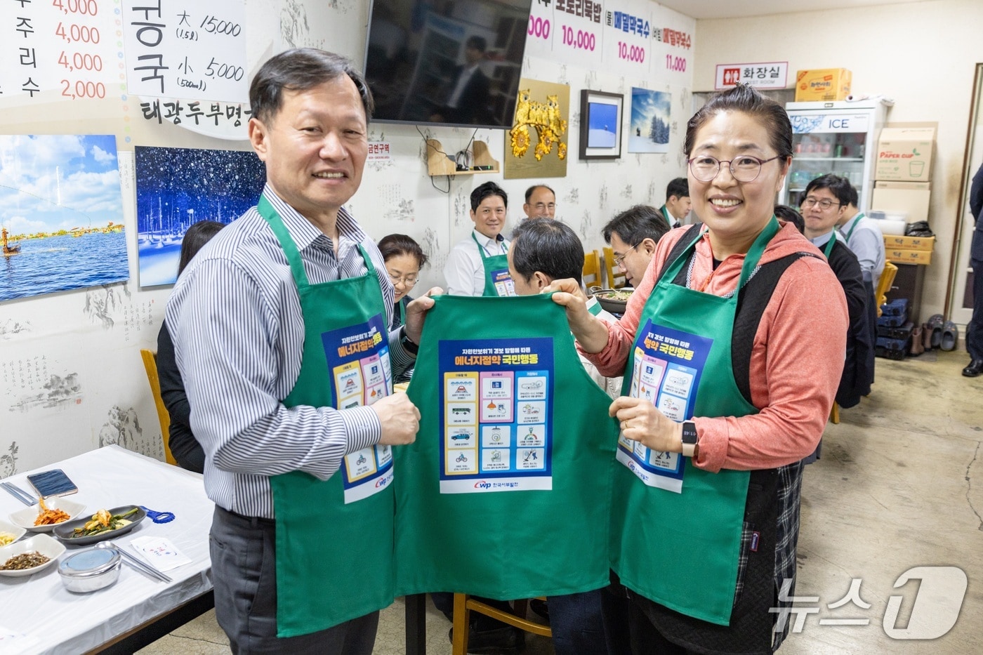 한국서부발전은 20일 본사가 있는 충남 태안군 일대에서 ‘지역 식당과 함께하는 에너지절약 실천 캠페인’을 추진했다. 사진은 이정복 서부발전 사장(왼쪽)과 지역 상인이 기념 촬영하는 모습.(사진제공=서부발전)