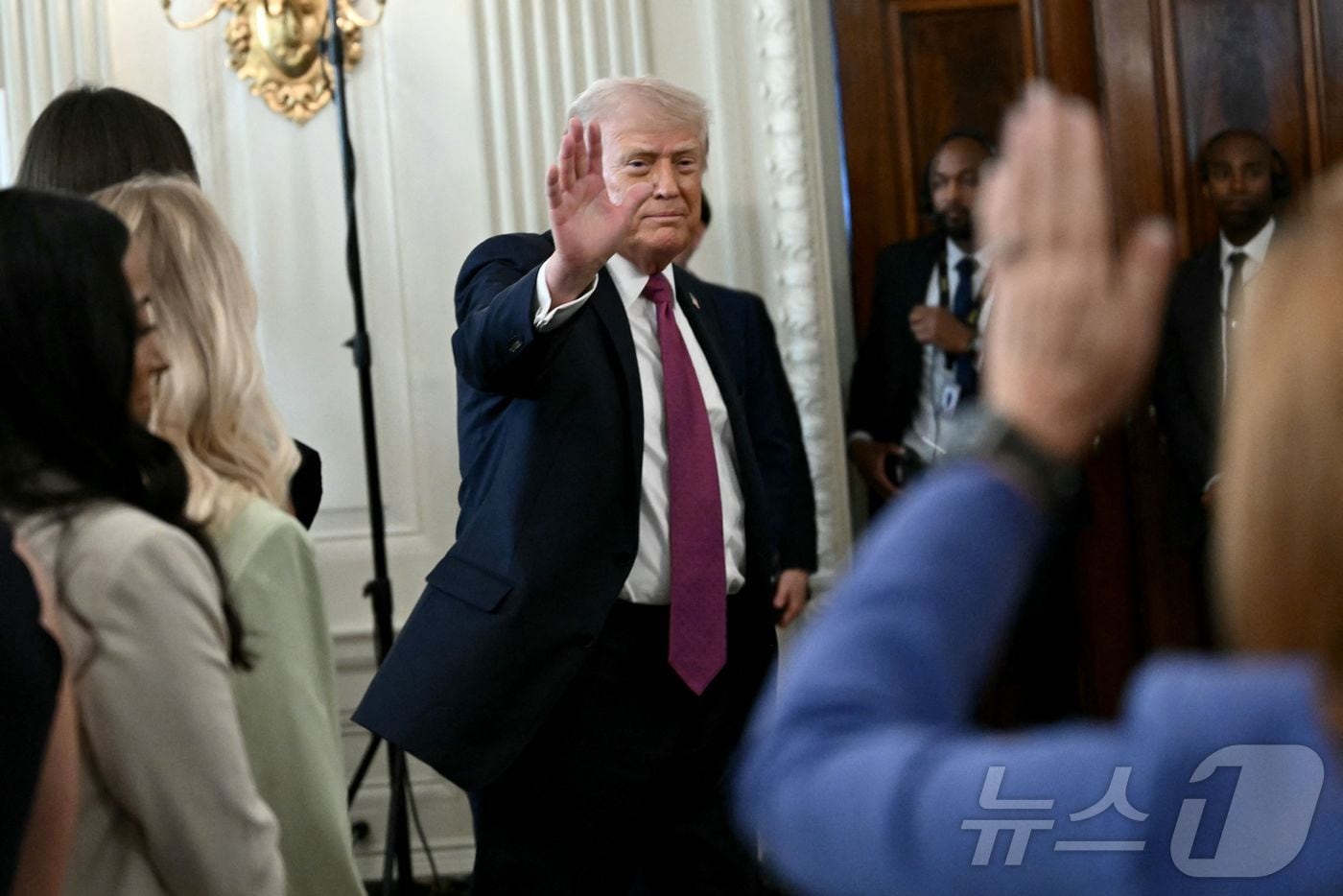 도널드 트럼프 미국 대통령이 21일(현지시간0 백악관에서 열린 NCAA 대학 국가 챔피언 기념 행사에서 질문을 하려는 기자를 향해 손을 흔들고 있다. 2026.04.21 ⓒ AFP=뉴스1