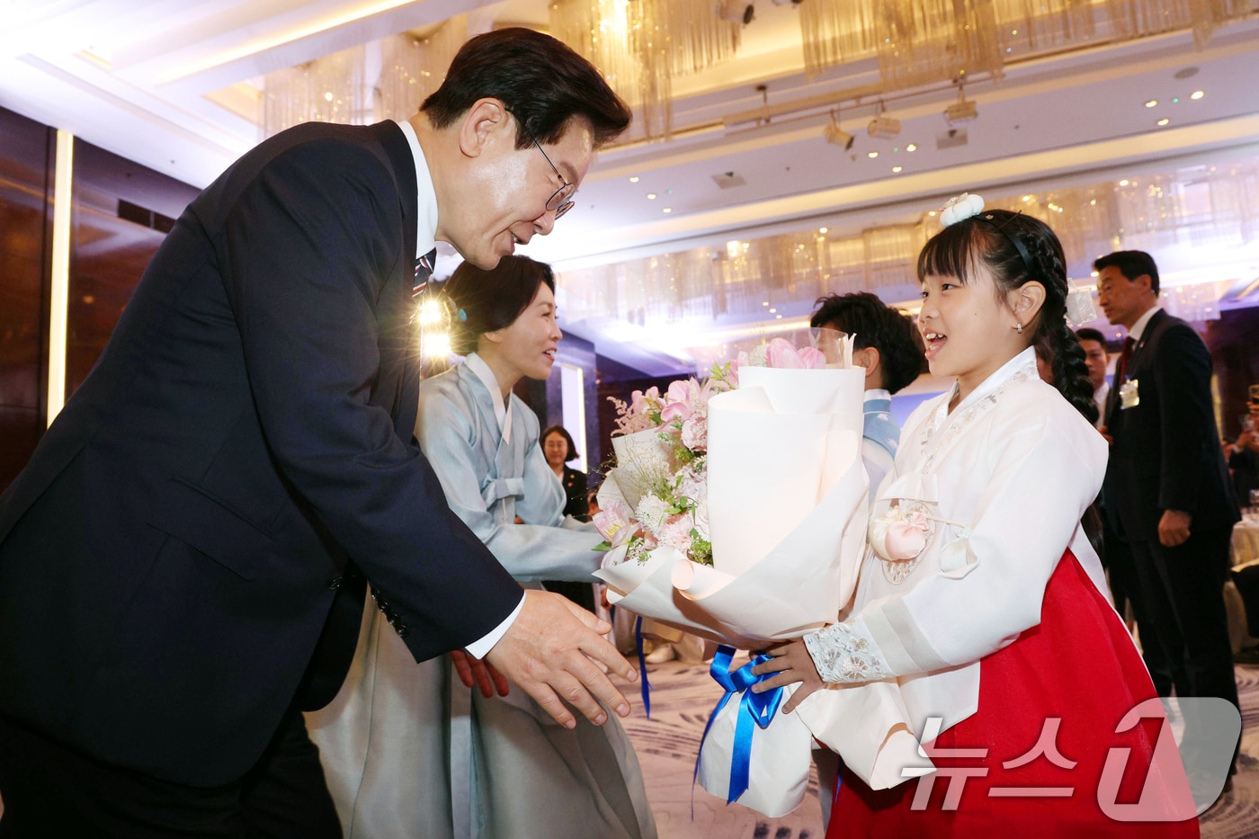 베트남을 국빈 방문 중인 이재명 대통령과 김혜경 여사가 22일(현지시간) 하노이의 한 호텔에서 열린 동포 오찬 간담회에서 화동에게 꽃다발을 받고 있다. 2026.4.22 ⓒ 뉴스1 이재명 기자