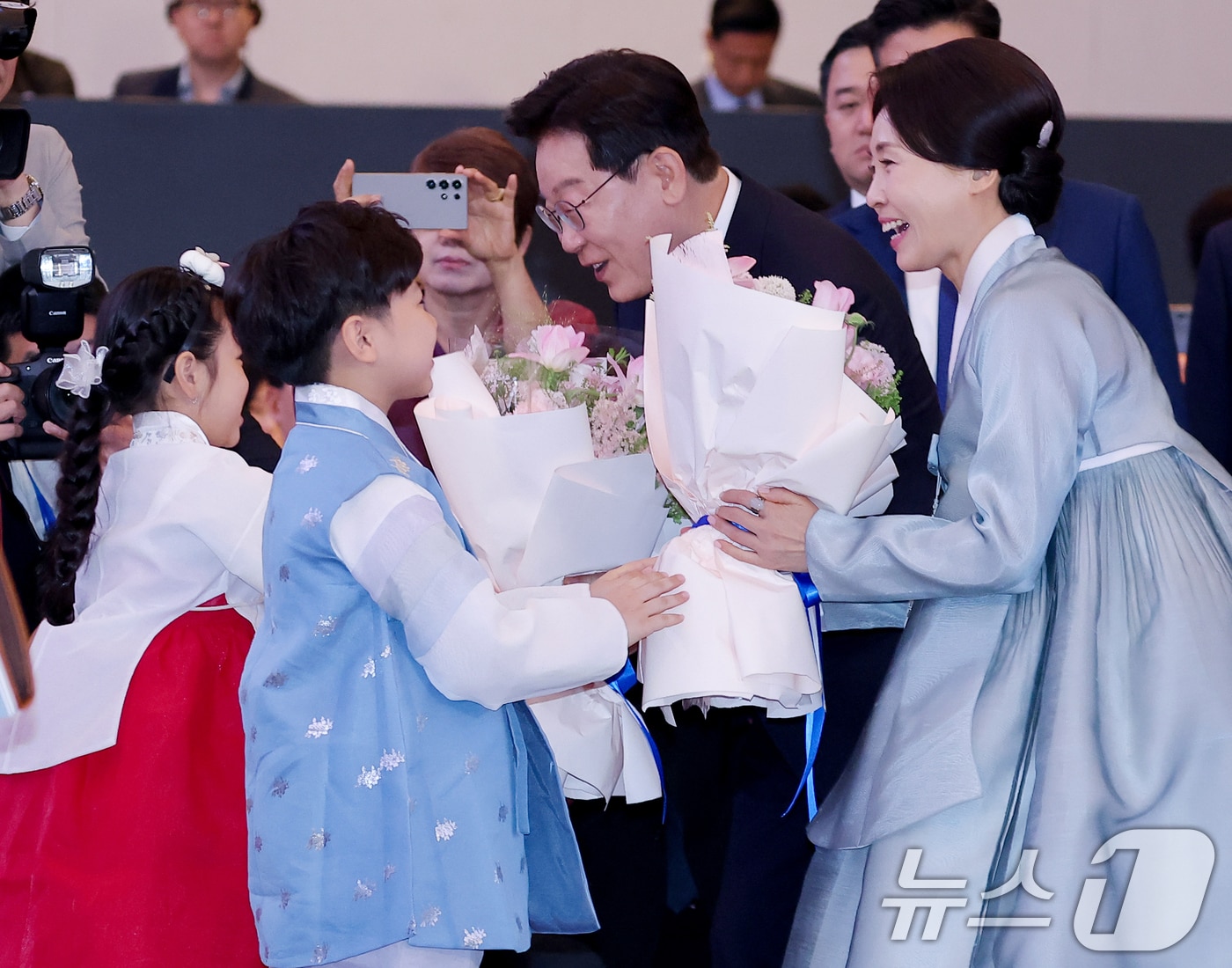 베트남을 국빈 방문 중인 이재명 대통령과 김혜경 여사가 22일(현지시간) 하노이의 한 호텔에서 열린 동포 오찬 간담회에서 화동에게 꽃다발을 받고 있다. 2026.4.22 ⓒ 뉴스1 이재명 기자