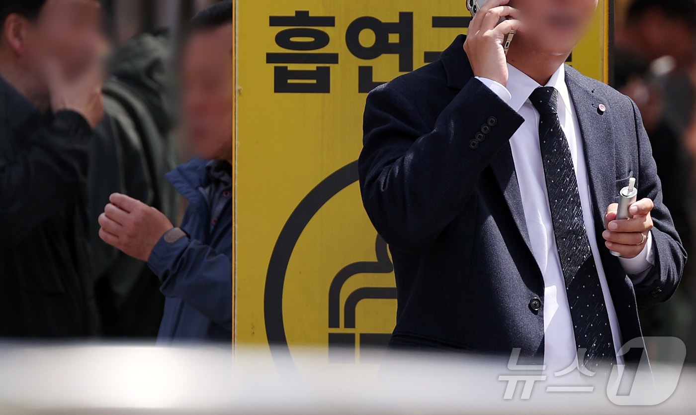 24일부터 합성 니코틴이 포함된 액상형 전자담배는 금연 구역에서 사용이 금지된다. 사진은 23일 서울 중구 서울역 인근 흡연장소에서 전자 담배를 피는 시민. 2026.4.23 ⓒ 뉴스1 김진환 기자